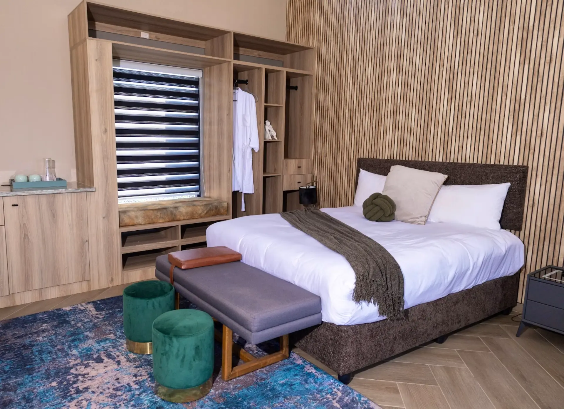Deluxe bedroom with slatted timber feature wall and upholstered bench