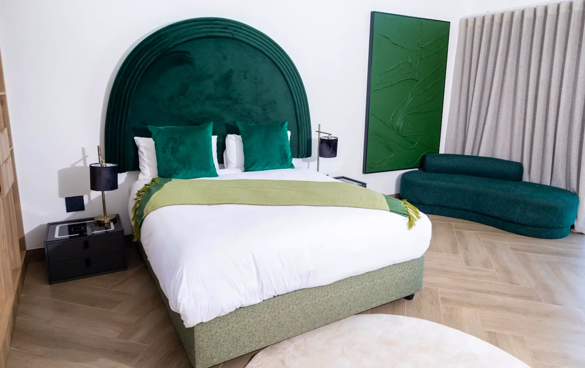Executive suite with emerald chaise lounge and arched headboard