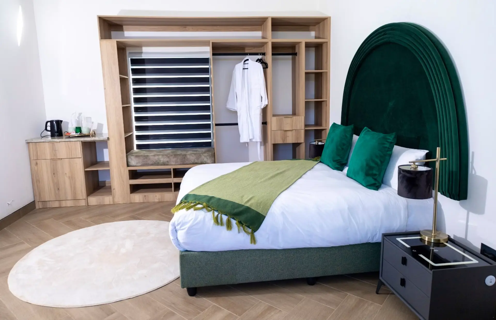 Executive suite with emerald arched velvet headboard and brass lamps
